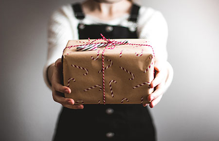 Eine Person, die ein Paket ins Bild hält